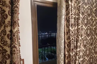 a window with a view of a city at night at Elminaa Residents 2 in Luxor