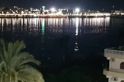 a large body of water at night with a city at El Minaa Residents 5 in Luxor
