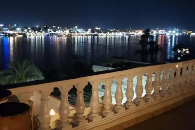a white railing with a view of the water at night at Elminaa Residents 3 in Luxor