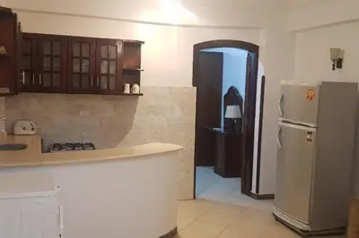 a kitchen with a refrigerator and a door to a room at Elminaa Residents 3 in Luxor