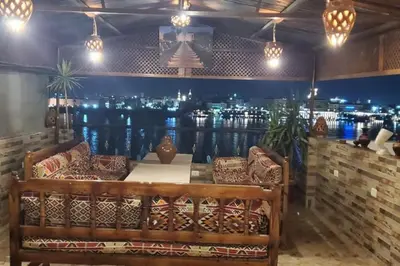 a bar with a bench and a table with lights at Elminaa Residents 3 in Luxor