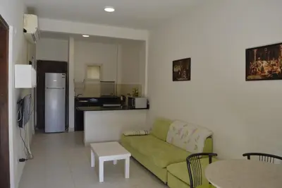 a living room with a green couch and a kitchen at Nice 2-Bed Apartment in Hurghada