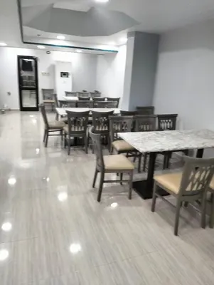 a dining room with tables and chairs in a restaurant at Emilio Hotel in Luxor