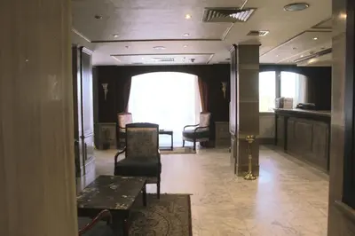 a hallway with chairs and a table in a building at Emilio Hotel in Luxor