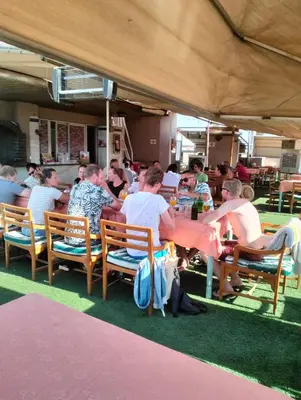 a group of people sitting at a table in a restaurant at Emilio Hotel in Luxor