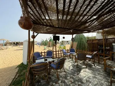 a group of chairs and tables under an umbrella on the beach at Ziena marvel camp in Quseir