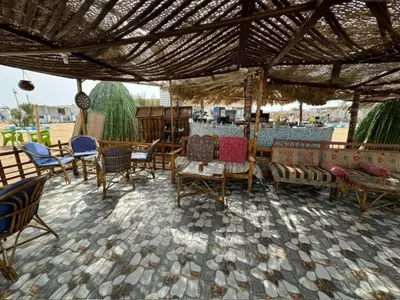 a patio with chairs and tables under a roof at Ziena marvel camp in Quseir