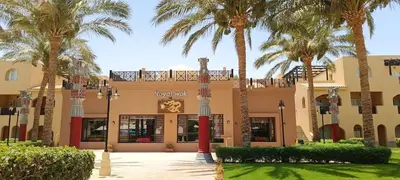 a building with palm trees in front of it at Apartment with services Stella Beach Resort 5 star Makadi bay Egypt in Hurghada