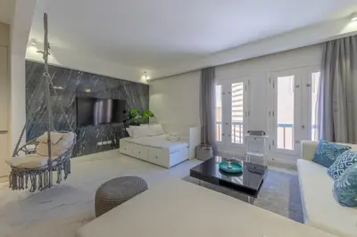 a living room with a white couch and a swing at Stylish Nest - New Marina - El Gouna in Hurghada
