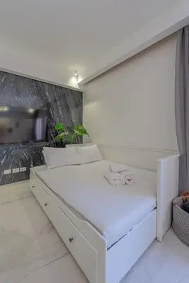 a white bed in a room with a wall at Stylish Nest - New Marina - El Gouna in Hurghada
