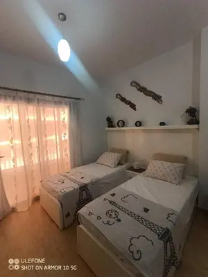 a bedroom with two beds and a window and avertisement at Turtles Beach Resort in Hurghada