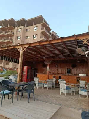a patio with chairs and tables and a building at Turtles Beach Resort in Hurghada