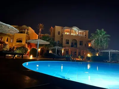 a large swimming pool in front of a house at night at Vue magnifique, confort unique in Hurghada