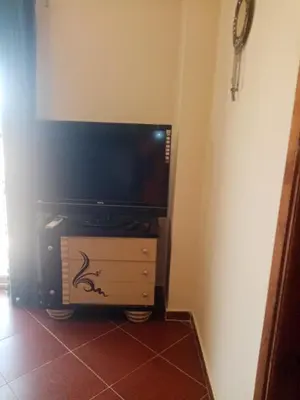 a living room with a tv and a dresser with a tvictericter at Family-friendly apartments in Hurghada in Hurghada