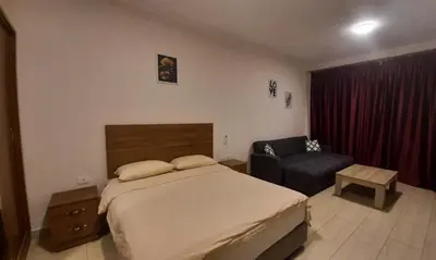a hotel room with a bed and a chair at Hurghada Aldau Heights Studio in Hurghada