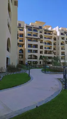 a large apartment building with a walkway in front of it at Hurghada Aldau Heights Studio in Hurghada