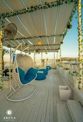 a deck with blue chairs and an umbrella at selena bay resort in Hurghada