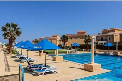 a swimming pool with chairs and umbrellas and a resort at selena bay resort in Hurghada