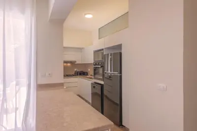 a kitchen with stainless steel appliances and white cabinets at Beach Front Paradise - 3 master beds - Abu Tig Marina - El Gouna in Hurghada