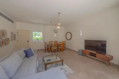 a living room with a couch and a tv and a table at Beach Front Paradise - 3 master beds - Abu Tig Marina - El Gouna in Hurghada