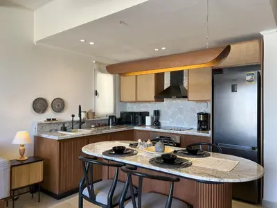 a kitchen with a large island in the middle at Casa De Madera - 1BR Sea & Golf View - Soma Bay in Hurghada
