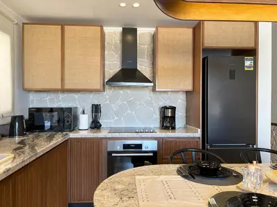 a kitchen with a counter top and a stove top oven at Casa De Madera - 1BR Sea & Golf View - Soma Bay in Hurghada
