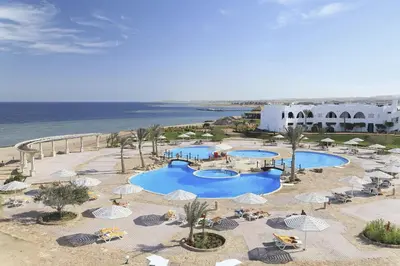 an aerial view of a resort with two pools and umbrellas at Three Corners Equinox Beach Resort in Abu Dabab