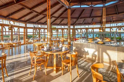 a dining room with tables and chairs in a restaurant at Three Corners Equinox Beach Resort in Abu Dabab