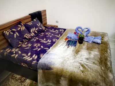 a bed with a table with a blue ribbon on it at Relax Home 1 in Hurghada