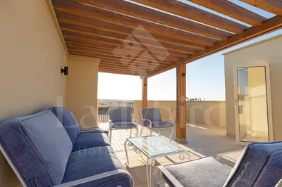 a living room with blue couches and a glass table at Ladybird - Veranda Highline in Hurghada