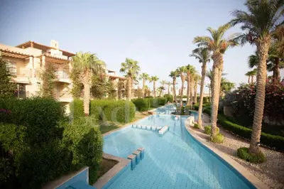 a swimming pool with palm trees in a resort at Ladybird - Veranda Highline in Hurghada