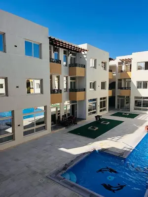 an apartment complex with a swimming pool in front of a building at Port Ghalib Apartments in Port Ghalib