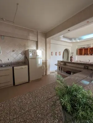 a large kitchen with a refrigerator and a counter at Aswan Nile view Family apartment in Aswan