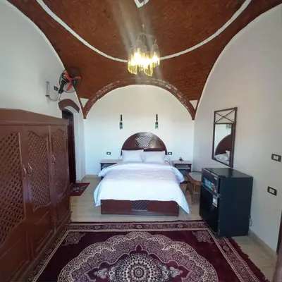 a bedroom with a bed and a chandelier at Villa Giulio - Guest House in Luxor