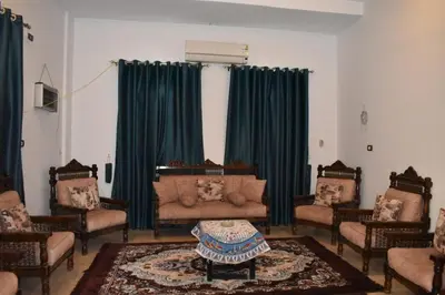 a living room with green curtains and a couch at Villa Giulio - Guest House in Luxor