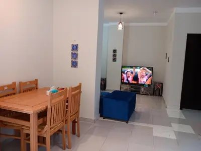 a dining room with a table and a tv at HW.Appartment in Hurghada