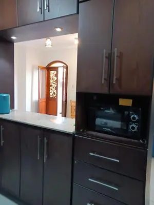 a kitchen with black cabinets and a microwave at HW.Appartment in Hurghada