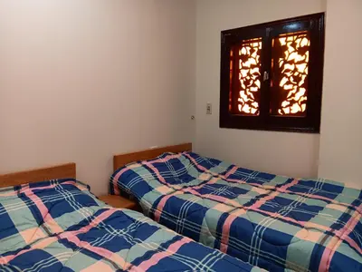 two beds in a room with a window at HW.Appartment in Hurghada