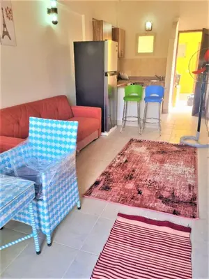 a living room with a red couch and a kitchen at 2 bedroom quiet flat at makadi heights in Hurghada