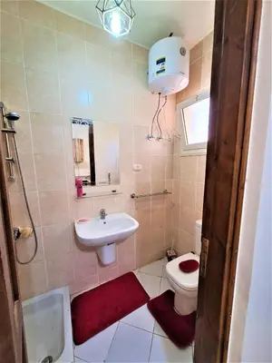 a bathroom with a sink and a toilet and a mirror at 2 bedroom quiet flat at makadi heights in Hurghada