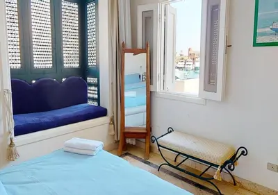 a bedroom with a bed and a bench in a window at Stylish Apartment 3 Brooms MB1at Marina Abu-Tig with Marina View in Hurghada