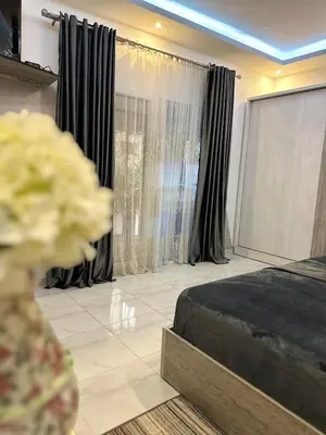 a bedroom with a bed and a window with curtains at Horizon on Mamsha 2 in Hurghada