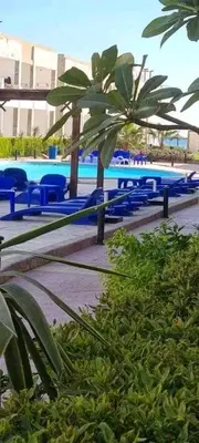 a group of blue chairs and a swimming pool at Apartment in Cecelia Resort in Hurghada