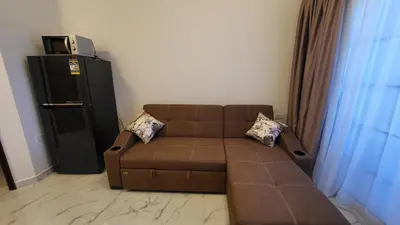 a living room with a brown couch and a refrigerator at Juliana beach in Hurghada