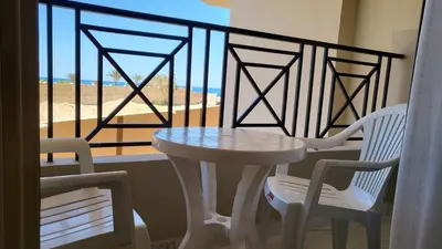a table and two chairs on a balcony with a view of the beach at Juliana beach in Hurghada