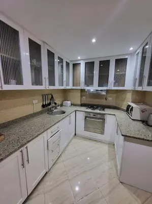 a large kitchen with white cabinets and a sink at Velký apartmán 50 m od pláže s přístupem zdarma- Sahl Hasheesh Hurghada resort Andalusie in Hurghada