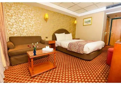 a hotel room with a bed and a couch at Nile Cruise from Aswan to Luxor 3 Night And Luxor to Aswan 4 Night in Jazīrat al ‘Awwāmīyah