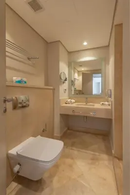 a bathroom with a toilet and a sink and a mirror at Modern 1BR, Mangroovy, Gouna - 1BR, Pool, & Beach in Hurghada
