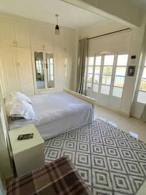 a bedroom with a white bed and a table at luxor Nile view duplex apartment in Luxor