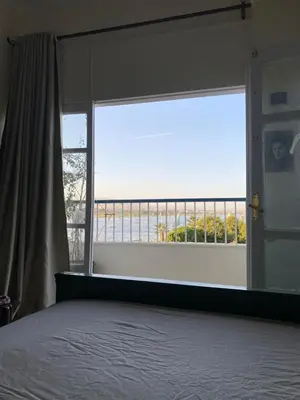 a bedroom with a bed and a large window at luxor Nile view duplex apartment in Luxor